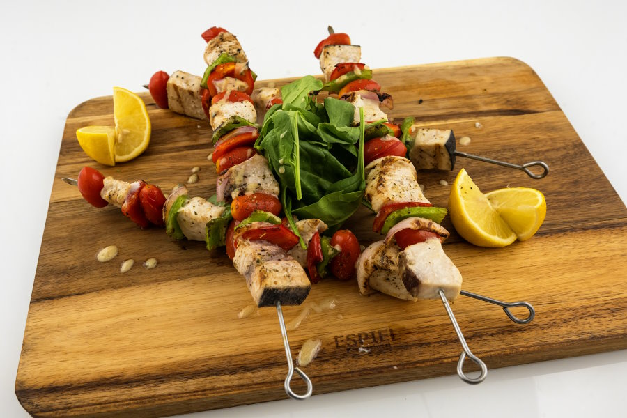 Souvlaki on a wooden plate cooked by Villa 1870 Corfu's Chef during a cooking lesson.